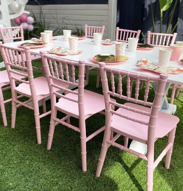 Pink kids chiavari chairs around a styled event table